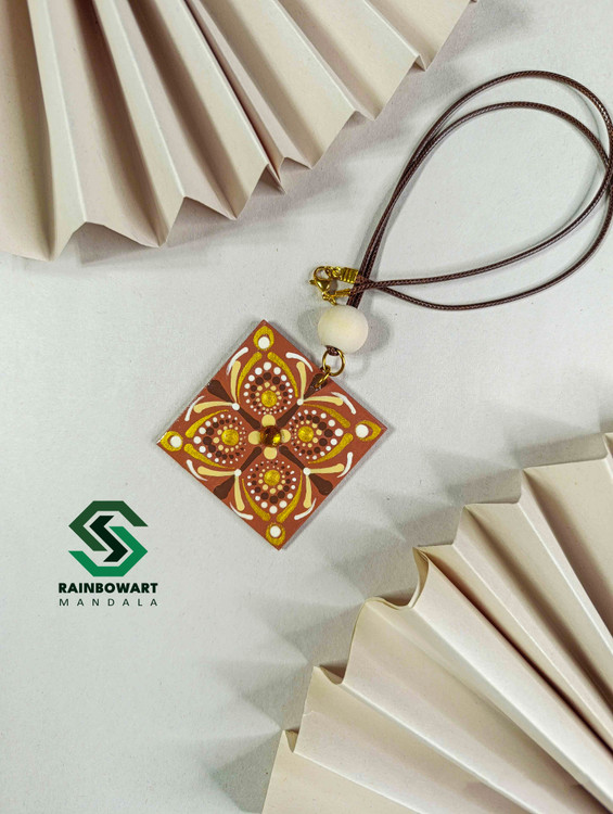 نمای دقیق از جفت گوشواره با طرح ماندالا و نقطهچینی – پسزمینه برگ گل، سبک boho chic