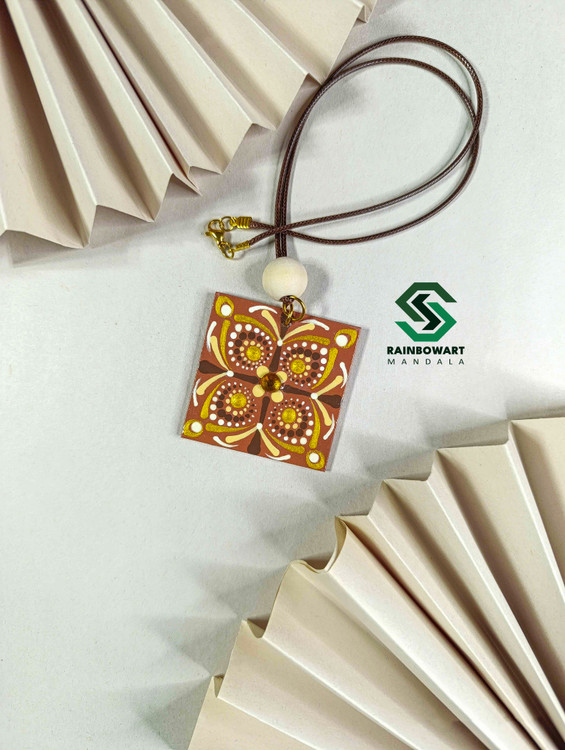 گوشوارههای چوبی مربعی رنگ قهوهای روشن با طراحی mandala art – عکاسی شده به سبک مینیمال روی برگ